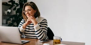 Middle aged woman looking up menopause resources on her laptop